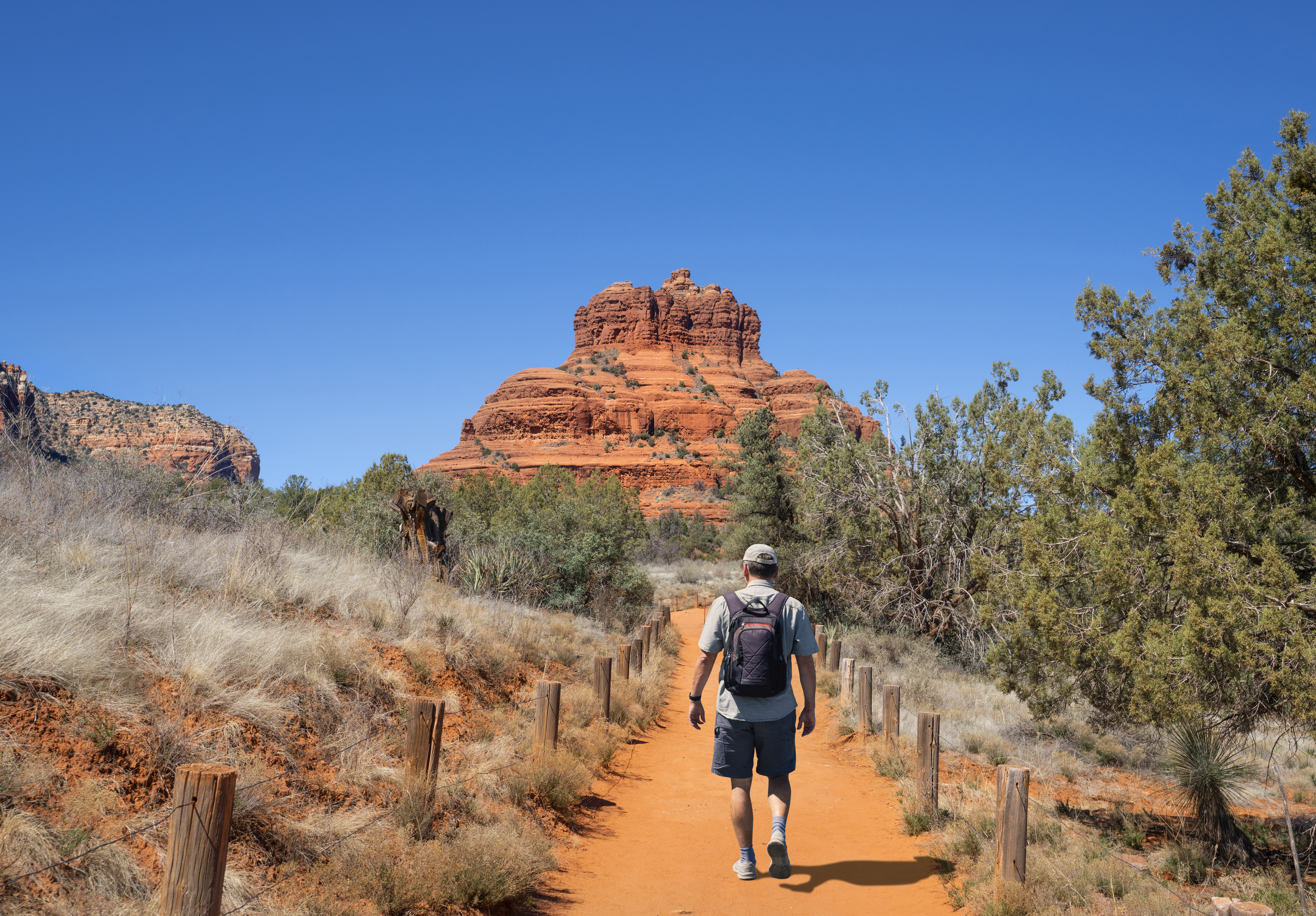 A man celebrates mens health month by hiking down a path in the desert.