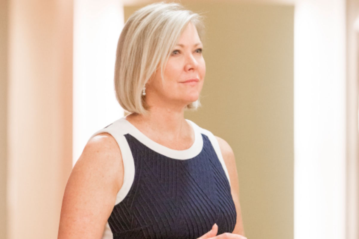 Professional woman with short blonde hair wearing a navy sleeveless dress with white trim, looking to the right.