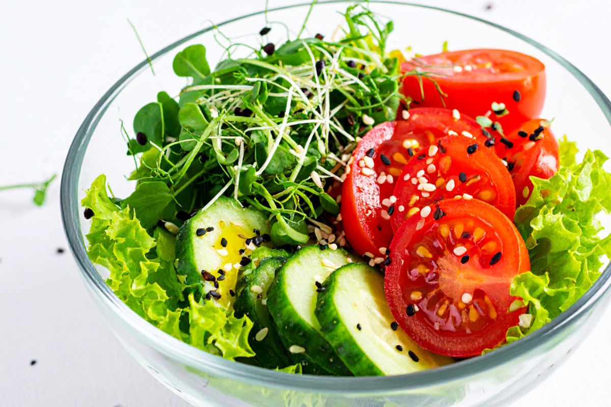 LS May HKHY Blog Image - LifeScape Concierge Primary Care, Aesthetics & Nutrition in Scottsdale Fresh vegetable salad in a glass bowl with lettuce, cucumber, tomato slices, sprouts, and sesame seeds on top.